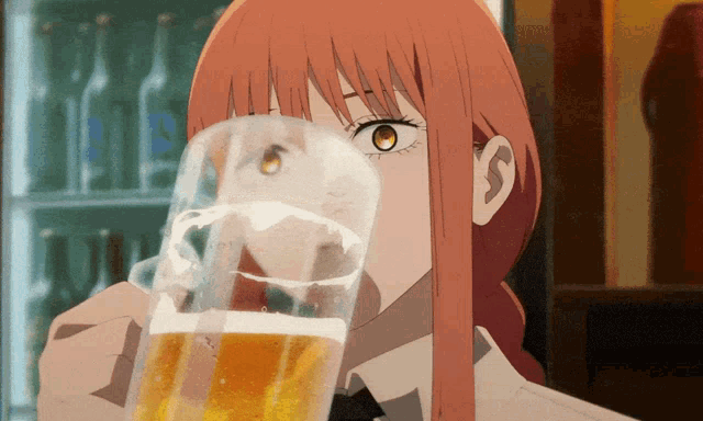 a woman with long red hair is drinking a glass of beer