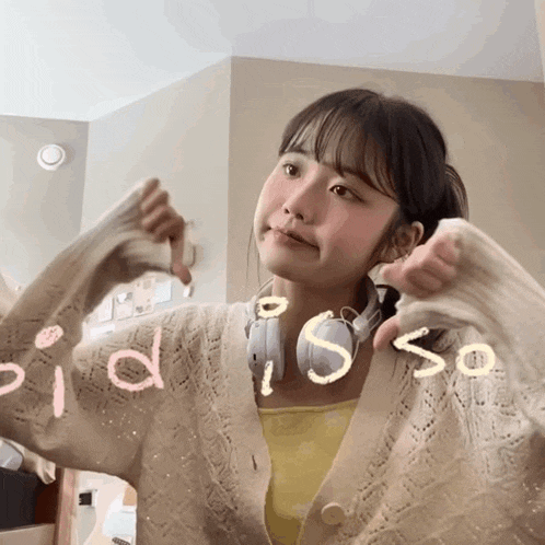 a girl wearing headphones and a sweater has the word " did " written on her sweater