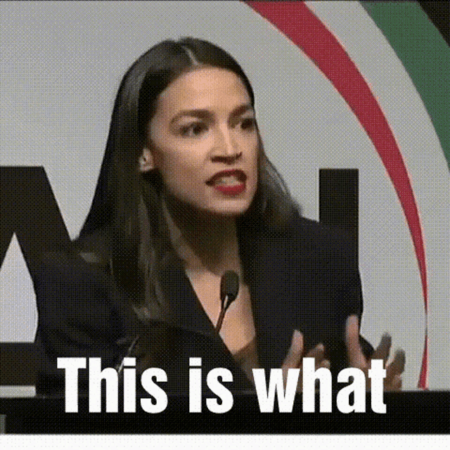 a woman is giving a speech in front of a microphone and the words `` this is what '' are written on the screen .
