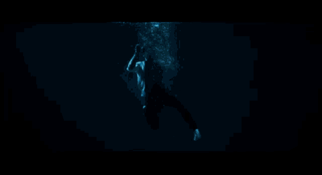 a silhouette of a man floating in the water