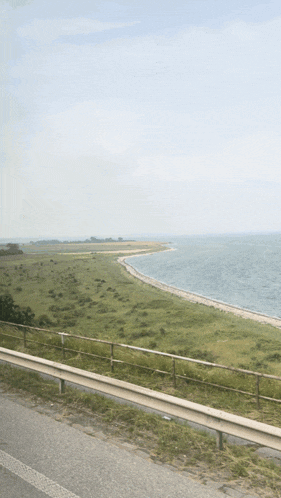 a view of a beach from a highway with a fence