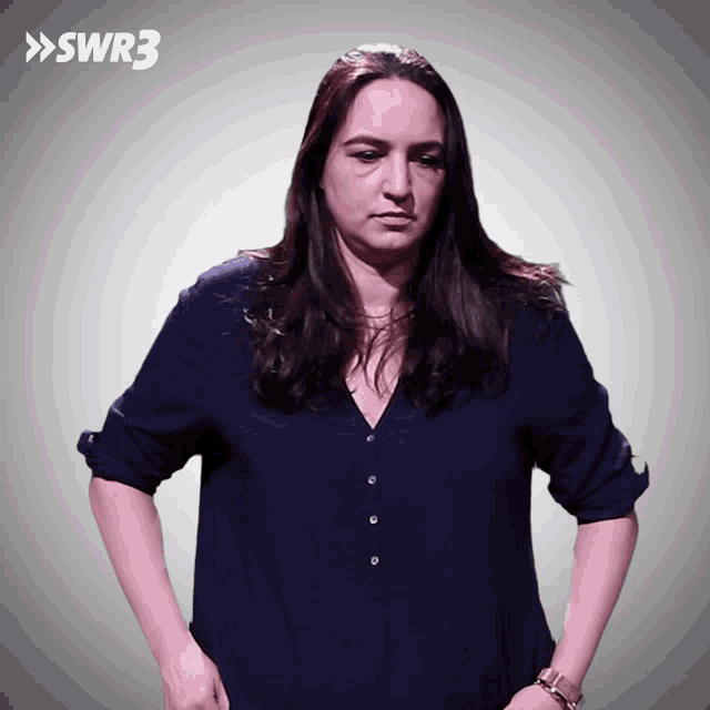 a woman in a blue shirt stands in front of a gray background with swr3 written on it