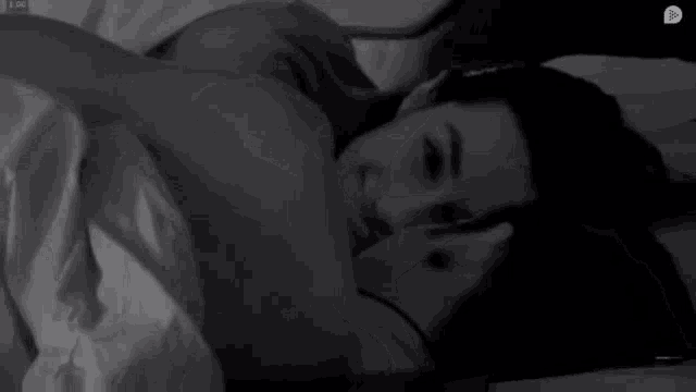 a man and a woman are sleeping in a bed together .