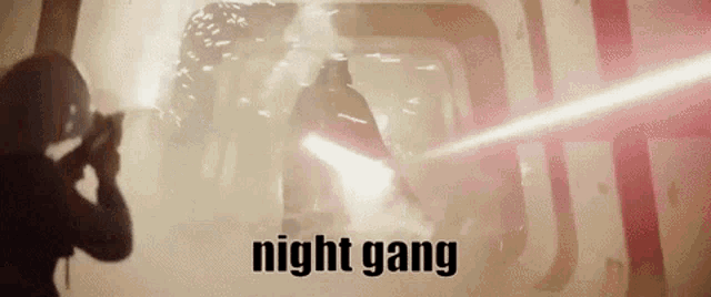 a man is holding a lightsaber in a dark room with the words night gang written above him