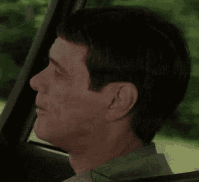 a man making a funny face while driving a car