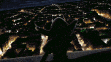 a person is standing in a dark room with a green and purple light coming out of their mouth .