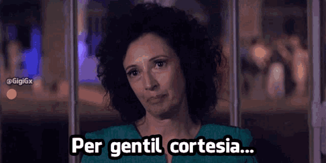 a woman with curly hair says per gentil cortesia in a foreign language