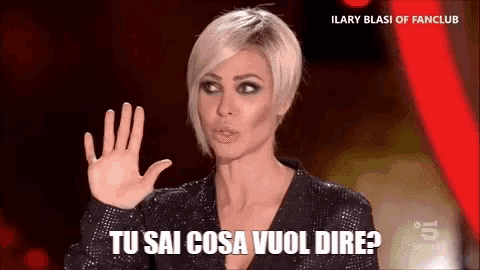 a woman is waving her hand and says tu sai cosa vuol dire .