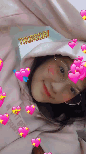 a girl wearing glasses and a hoodie with the word thursday above her head