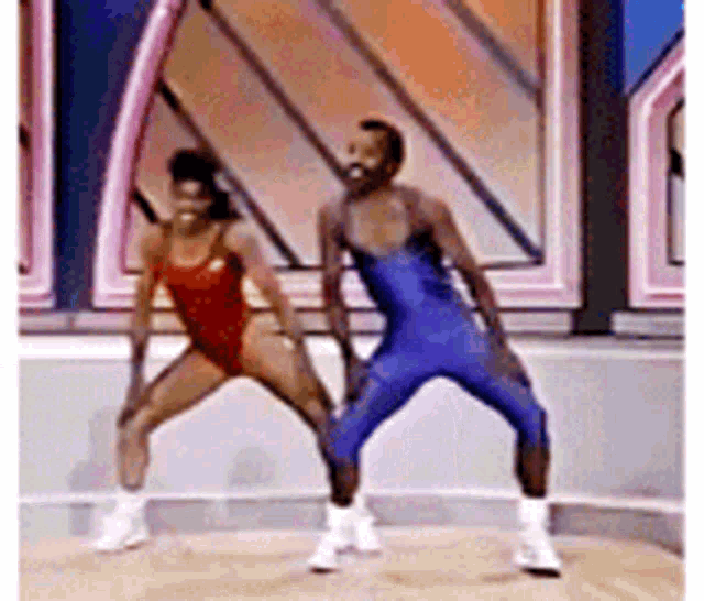 a man and a woman are dancing together on a stage in a gym .