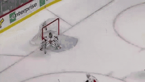 a hockey player is laying on the ice with his head on his chest .