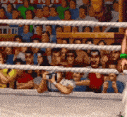 a pixelated image of a boxing ring with a crowd of people watching