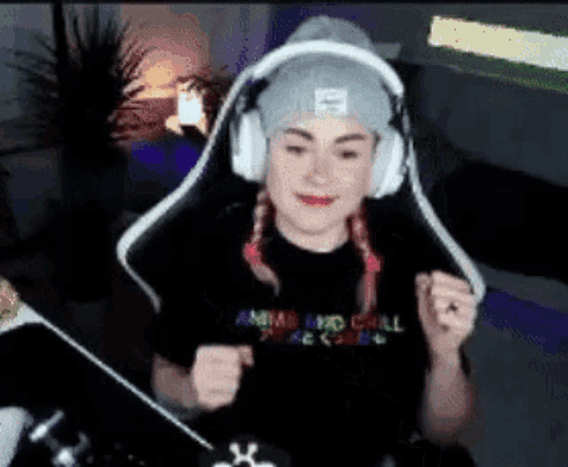 a girl wearing headphones and a beanie is sitting in a chair .