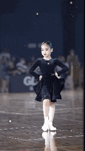 a little girl is dancing on a dance floor .