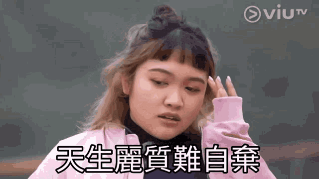 a woman in a pink jacket holds her hand to her forehead in front of a viu tv logo