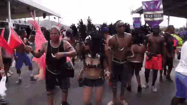 a group of people are dancing in front of a banner that says black swan
