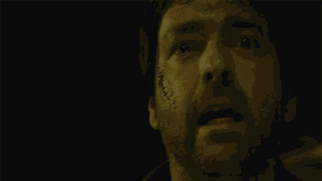 a close up of a man 's face with a black background