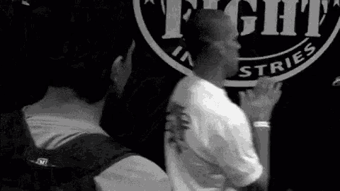 two men are standing in front of a sign that says fight industries .