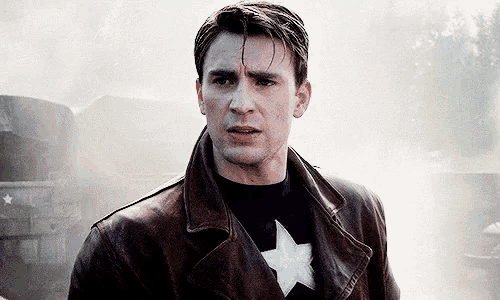 a close up of a man wearing a leather jacket and captain america 's uniform .