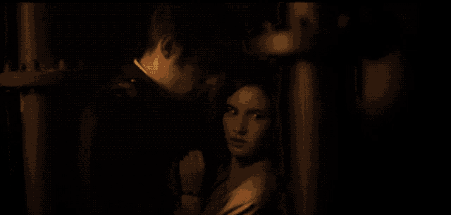 a man and a woman are standing in the dark