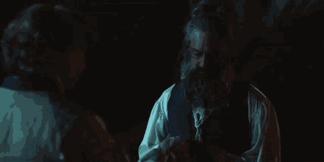 a man with a beard is holding a baby in his arms .
