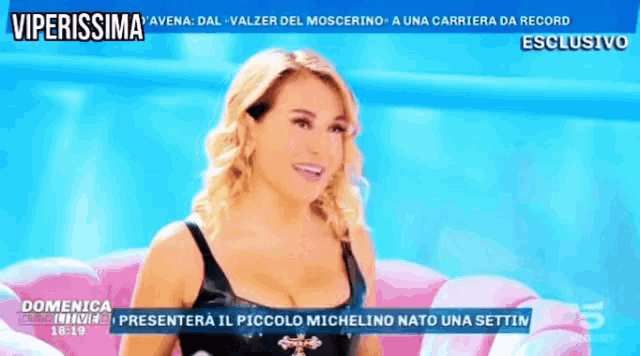 a television screen shows a woman sitting on a pink couch and the time is 18:19