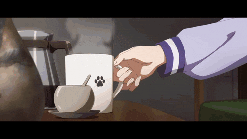 a person is holding a cup of coffee with a paw print on it