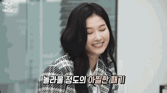 a woman in a plaid jacket is smiling with her eyes closed in a room .