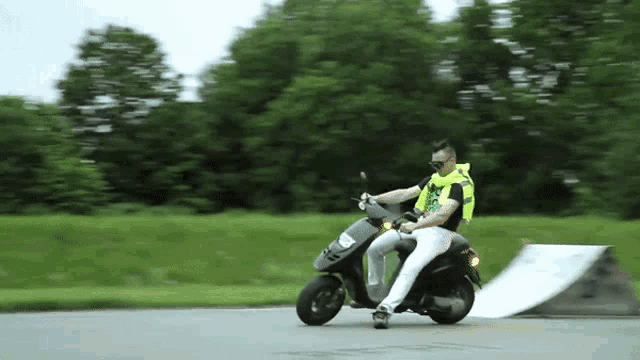 a man riding a scooter with the number 4 on the front