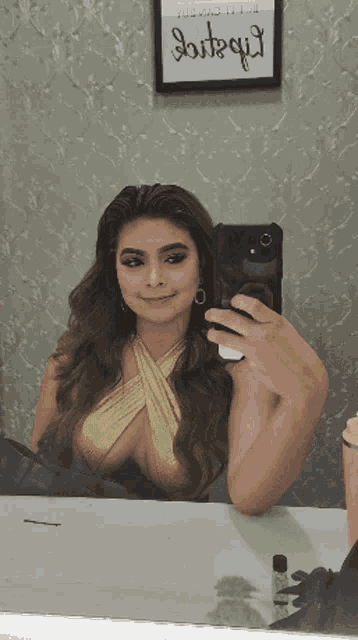 a woman taking a picture of herself in front of a sign that says ' bitsqui '