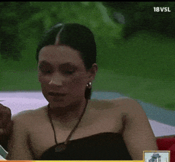 a woman is sitting in front of a screen that says 18vsl on it