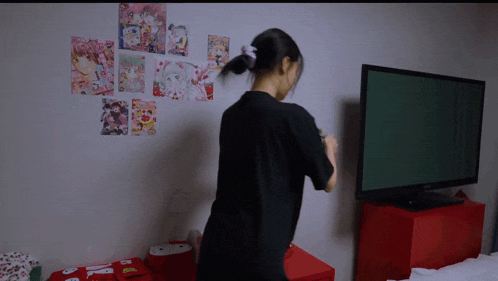 a woman in a black shirt stands in front of a samsung tv