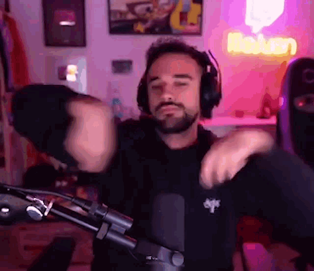 a man wearing headphones is dancing in front of a microphone .