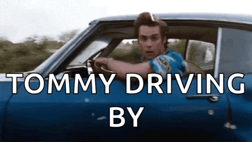 a man is driving a blue car with the words tommy driving by
