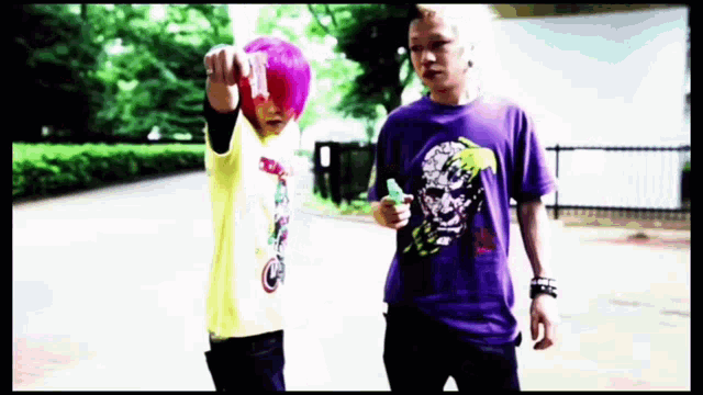 a man in a purple shirt with a skull on it stands next to another man in a yellow shirt