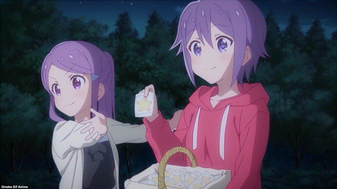 two anime girls are standing next to each other and one is holding a basket of cookies .