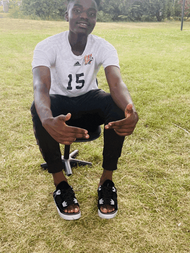 a man with the number 15 on his shirt sits on a chair