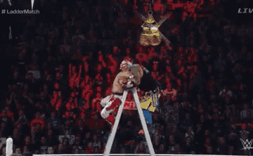 a wrestler jumps over a ladder in a wrestling ring