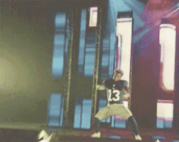 a man wearing a jersey with the number 13 on it is dancing on a stage