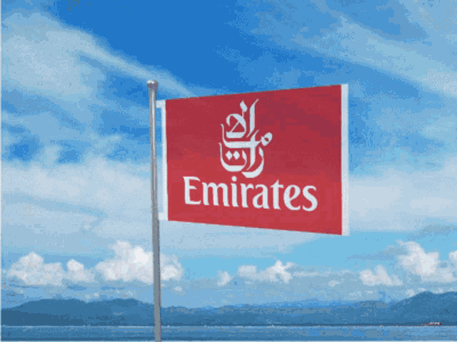 a red and white emirates flag is flying in the wind