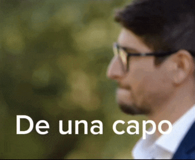 a close up of a man wearing glasses with the words de una capo behind him