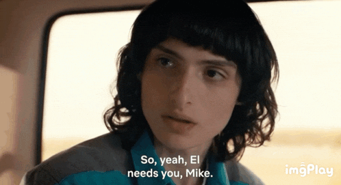 a young man with curly hair is sitting in a car and says so yeah el needs you mike .