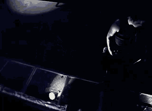 a black and white photo of a man standing in the dark