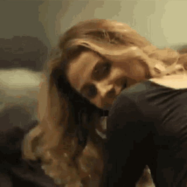 a woman is laying on a couch with her head on a man 's shoulder and her eyes closed .