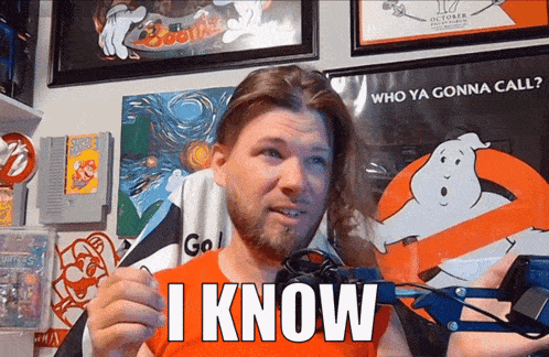 a man with a beard holds up a sign that says " i know "