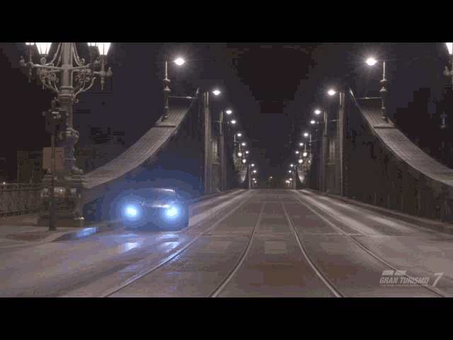 a car is driving across a bridge that says gran turismo on it