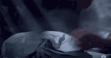 a person is laying on a bed with a pillow and a blanket .