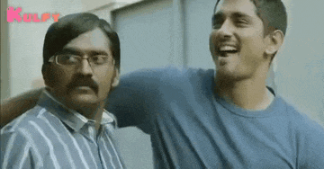 two men are standing next to each other and laughing together .