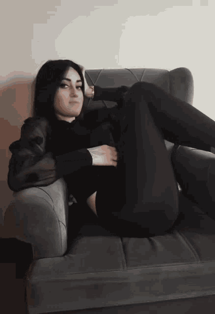 a woman laying on a couch with her legs crossed