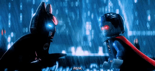 a lego batman and superman standing next to each other